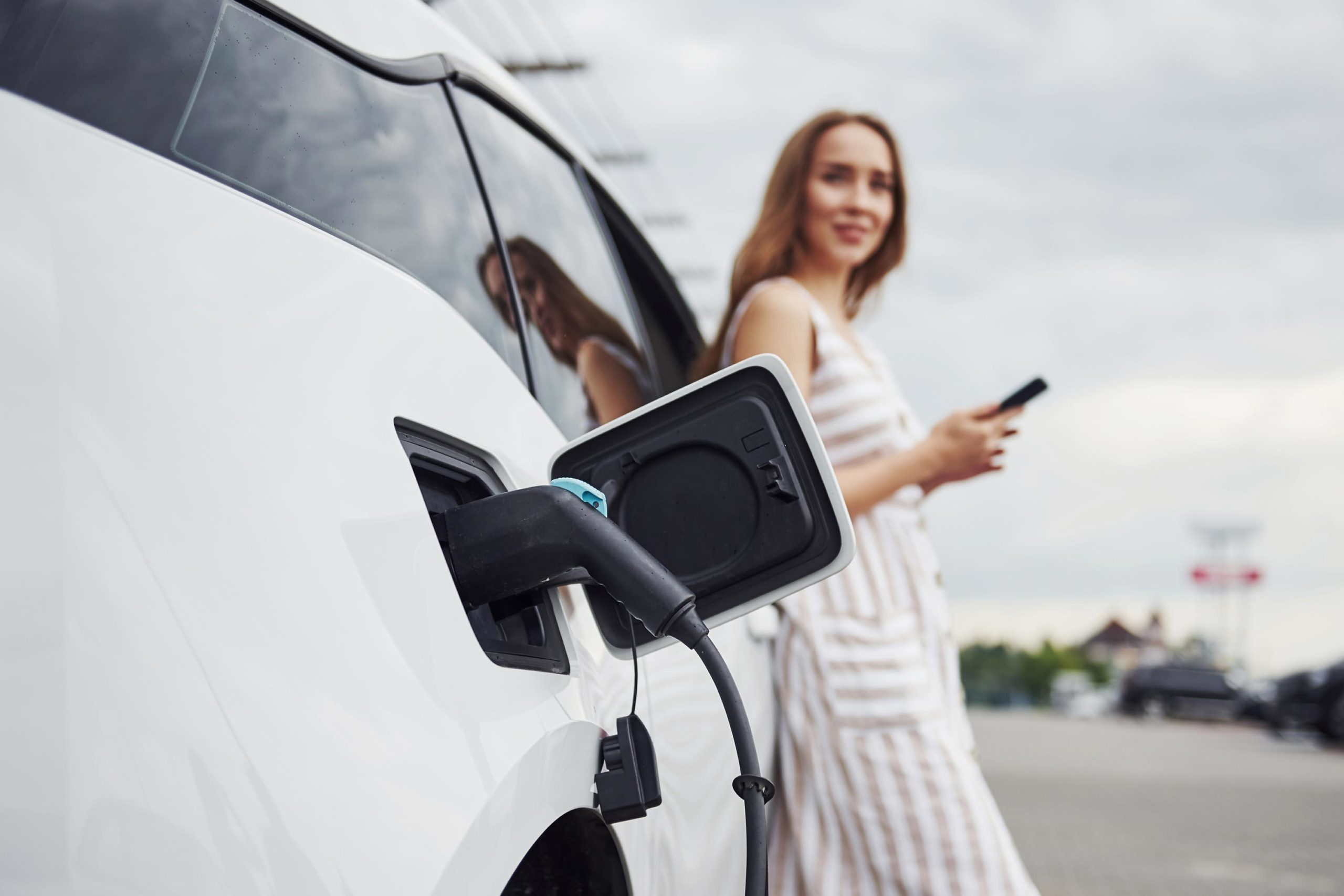 frau-laedt-e-car-auf-parkplatz